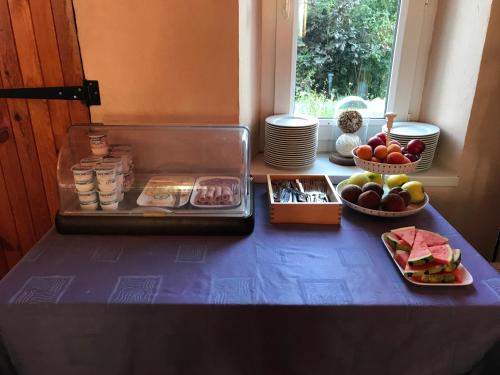 a table with plates of food and bowls of fruit at Hotel La Prairie in Méaudre