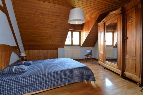 a bedroom with a bed with a blue and white checked blanket at S'Harzala Bleu in Bergheim