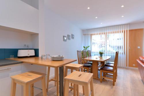 une cuisine et une salle à manger avec une table et des chaises dans l'établissement S'Harzala Bleu, à Bergheim