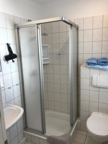 ein Bad mit einer Dusche, einem WC und einem Waschbecken in der Unterkunft Stadthaus in Westerland