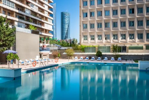 a swimming pool in a city with buildings at Hotel Madrid Chamartín, Affiliated by Meliá in Madrid