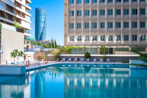 a swimming pool in a city with buildings at Hotel Madrid Chamartín, Affiliated by Meliá in Madrid