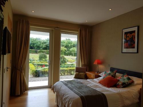 una camera da letto con un letto e una grande finestra di Hazelwood Country House a Adare