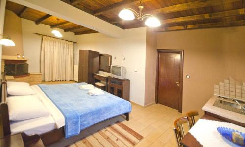 ein Schlafzimmer mit einem Bett und eine Küche mit einem Waschbecken in der Unterkunft Guesthouse Oneiro in Kato Loutraki