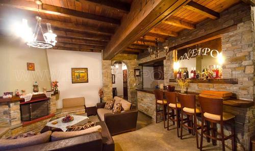 a living room with a bar and a stone wall at Guesthouse Oneiro in Kato Loutraki