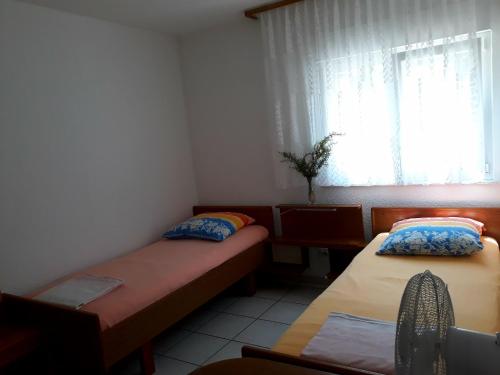 a small room with two beds and a window at Casa Gudelj in Pirovac