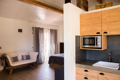 a room with a bed and a kitchen with a microwave at Herdade das Barradas da Serra in Grândola