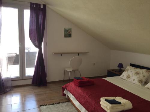 a bedroom with a bed and a large window at Apartment Inter Vivos in Smokvica