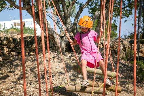 a little girl riding on a rope swing at RVHotels Ametlla Mar in L'Ametlla de Mar