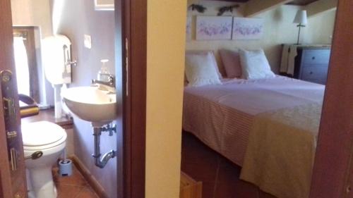 a bathroom with a bedroom with a bed and a sink at Casale Angeli in Narni in Narni
