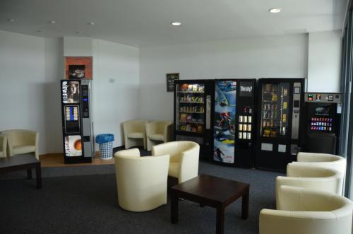 a room with two vending machines and chairs at Low Budget Hostel in Munich