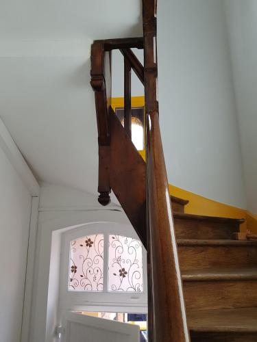 a wooden staircase in a room with a window at Appartement atypique - 2 chambres - rue calme dans centre ville in Sedan