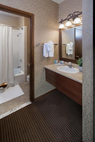 a bathroom with a sink and a tub and a shower at Grand Gateway Hotel in Rapid City