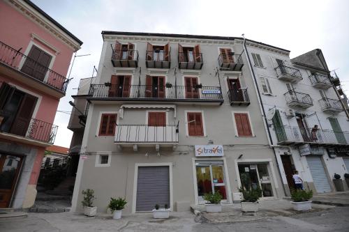 un edificio alto de color blanco con balcones y ventanas en Pensione Oliva, en Lagonegro