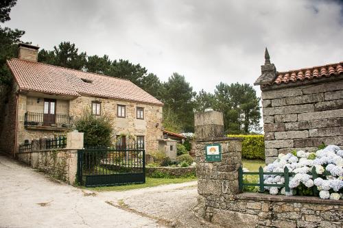 a stone house with a gate in front of it at Casal de Cereixo in Tufiones