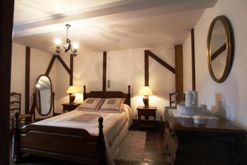 Un dormitorio con una cama y dos espejos en la pared. en Gîte Yanou, en Sault-de-Navailles