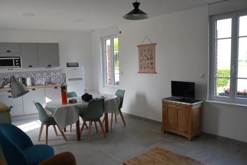 une cuisine et une salle à manger avec une table et des chaises dans l'établissement Le Cottage, à Harbonnières