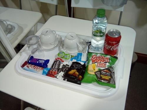 ein Tablett mit Snacks und einer Flasche Wasser auf dem Tisch in der Unterkunft West Brae Inn in Paisley