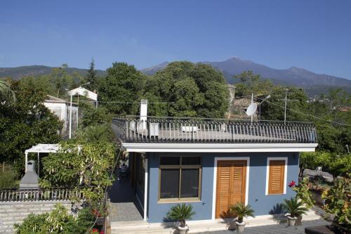 a blue house with a balcony on top of it at Etna Sweet Home in Santa Venerina
