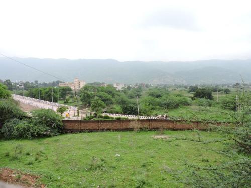 a train is traveling down a hill near a field at Radhika Palace Hotel in Pushkar