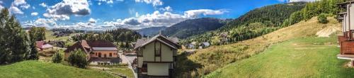 a view of a village on a hill with mountains at Snowflake Chalet ,Donovaly in Donovaly