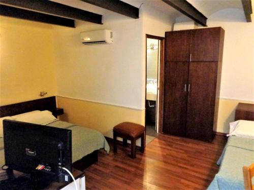a room with a bedroom with a bed and a cabinet at Hotel Casablanca Montevideo in Montevideo