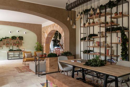 a dining room with a table and shelves with plants at Momentum Wellness Bioresort in Marinella di Selinunte