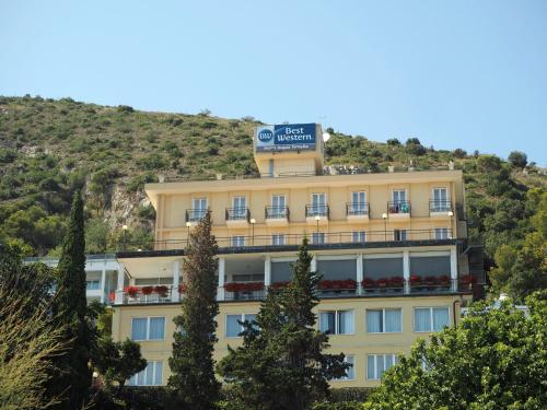 a yellow building with a sign on top of it at Best Western Hotel Acqua Novella in Spotorno