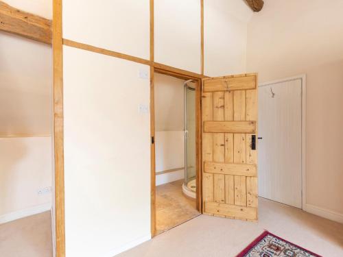 a bathroom with a sliding door and a toilet at Pilgrim Cottage in Bourton on the Hill