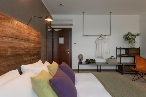 a bedroom with a white bed with colorful pillows at Momentum Wellness Bioresort in Marinella di Selinunte