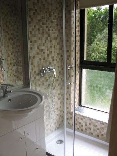 a bathroom with a shower and a sink and a window at Campismo Rural Vale dos Moinhos Gerês in Geres