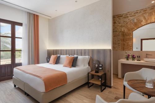 a hotel room with a bed and a table at Momentum Wellness Bioresort in Marinella di Selinunte