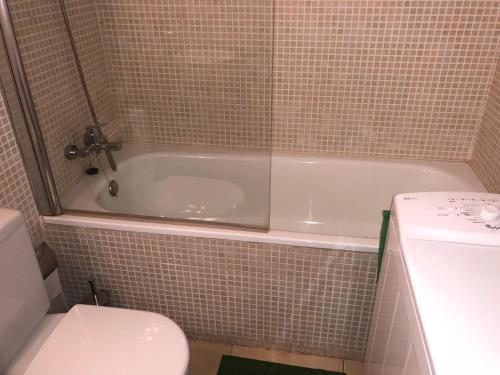 a bathroom with a white tub and a toilet at Goldhome - Cristallmar in Empuriabrava