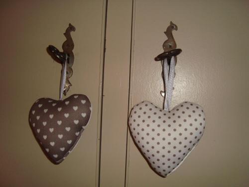 two hearts hanging on hooks on a door at La Clochette in Celles