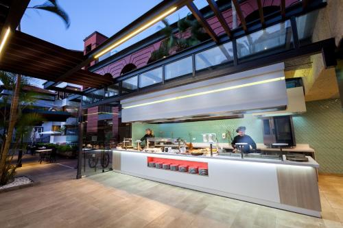 a restaurant with a counter with people preparing food at Gran Tacande Wellness & Relax Costa Adeje in Adeje