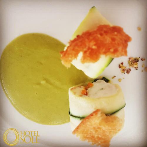 a plate of food with cheese and sauce on it at Hotel Sole in Lampedusa