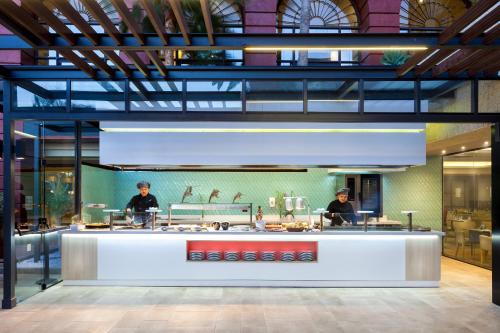 two men standing behind a counter in a restaurant at Gran Tacande Wellness & Relax Costa Adeje in Adeje