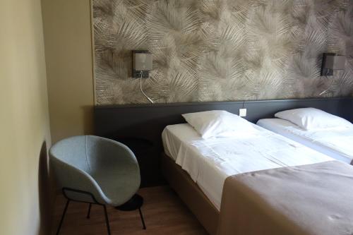 a hotel room with two beds and a chair at La Clochette in Celles