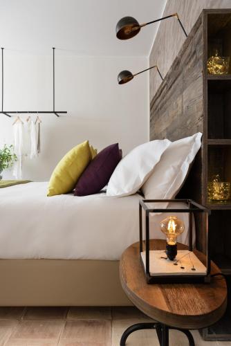 a bedroom with a bed with pillows and a table at Momentum Wellness Bioresort in Marinella di Selinunte