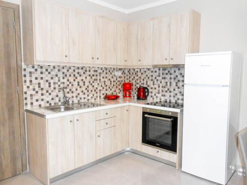 a kitchen with a white refrigerator and a microwave at 7 Islands in Alykes