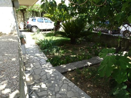 a garden with a car parked in a driveway at Job studio apartments in Split