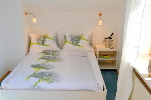 ザンクト・ヴォルフガングにあるハウス シーガートゥンのベッドルーム1室(花を描いたベッド2台付)