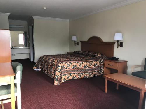 a hotel room with a bed and a table at Bayfront Inn Biloxi in Biloxi