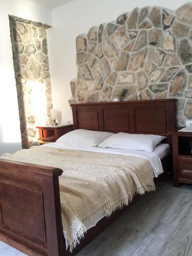 a bed in a room with a stone wall at Apartments Pomeštak in Pomena