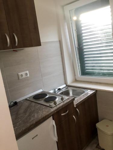 a small kitchen with a stove and a sink at Apartments Pomeštak in Pomena