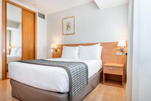 a bedroom with a large bed in a hotel room at Exe Puerta San Pedro in Lugo