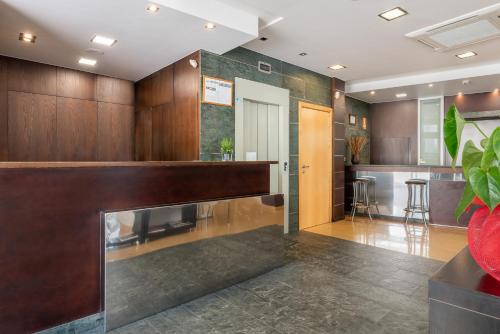 a lobby with a bar with wood paneling at Exe Puerta San Pedro in Lugo