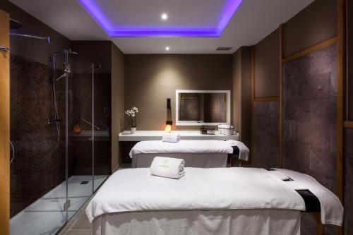 a spa room with two beds and a shower at Gran Tacande Wellness & Relax Costa Adeje in Adeje