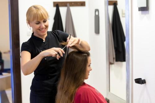 a woman cutting a girls hair in a salon at Gran Tacande Wellness & Relax Costa Adeje in Adeje