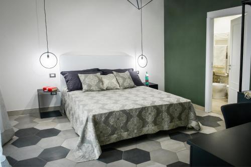 a bedroom with a bed and a black and white floor at Big Rose in Rossano